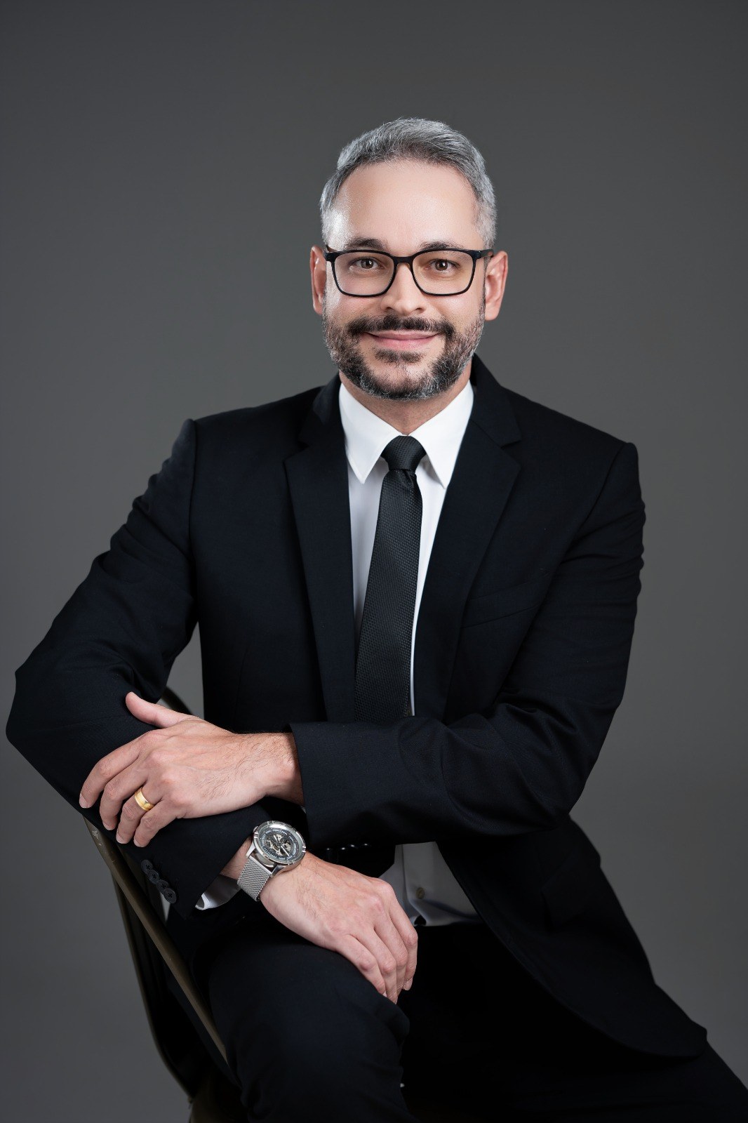 Dr. Rodrigo Linhares, cardiologista, CRM-MT 10564, sentado com os braços cruzados em retrato para a seção sobre o médico
